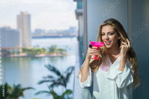 Sensual woman enjoy drink coctail at terrace balcony on summer vacation time. Elegant woman drinking alcoholic cocktail on home. Beautiful young woman drinking cocktail.