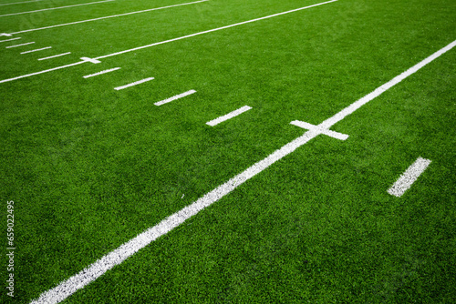 Football field green artificial turf with white lines and hash marks