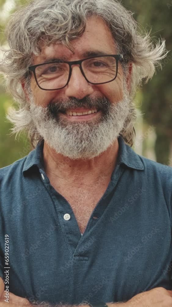 Close-up of an elderly man crossing his arms and looking at the camera with smile Close-up of an elderly man crossing his arms and looking at the camera with smile