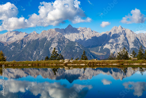 Fototapeta Naklejka Na Ścianę i Meble -  The Kaltwassersee lake in Seefeld/Tyrol. The mountains and the clouds are reflected in the cold clear water of the mountain lake