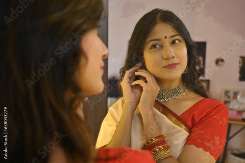 Woman getting ready infront of the mirror. Indian woman watching on mirror. Traditional look. Saree and jewellery. Maharashtra. Beautiful Bride