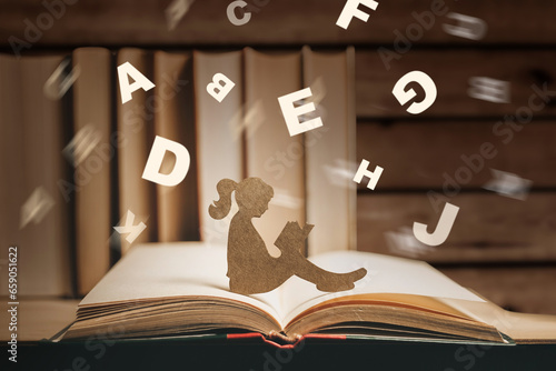 girl with dyslexia holds a book. Flying tangled letters in the air. The child learns to speak and read correctly