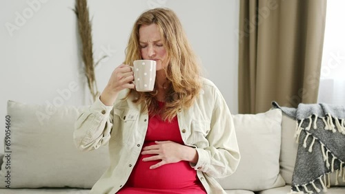 A young pregnant woman suffers from toxicosis. The expectant mother feels nauseous and develops an aversion to the smells of food and drinks. Pregnancy side effects photo