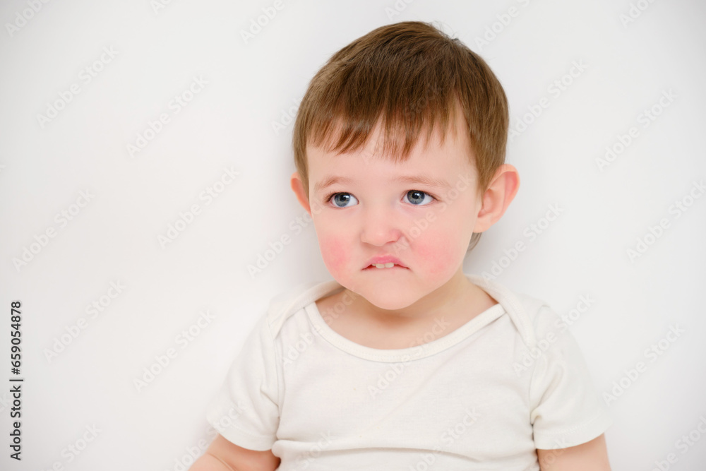 Offended baby looks pursed lips, studio white background. Sad child with the emotion of resentment on his face. Kid about two years old (one year nine months) Offended baby looks pursed lips, studio white background. Sad child with the emotion of resentment on his face. Kid about two years old (one year nine months)