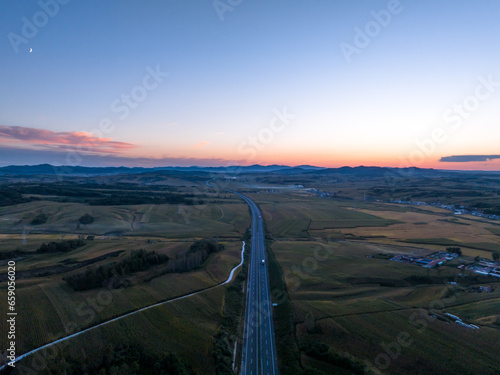 aerial view of highway in countryside at sunset