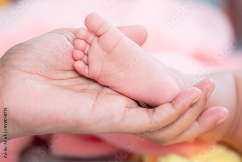 baby feet,Banner. Mother holding in the hands feet of newborn baby. Baby feet in mother hands. Tiny Newborn Baby's feet on female Shaped hands closeup. Mom and her Child. Happy Family concept.