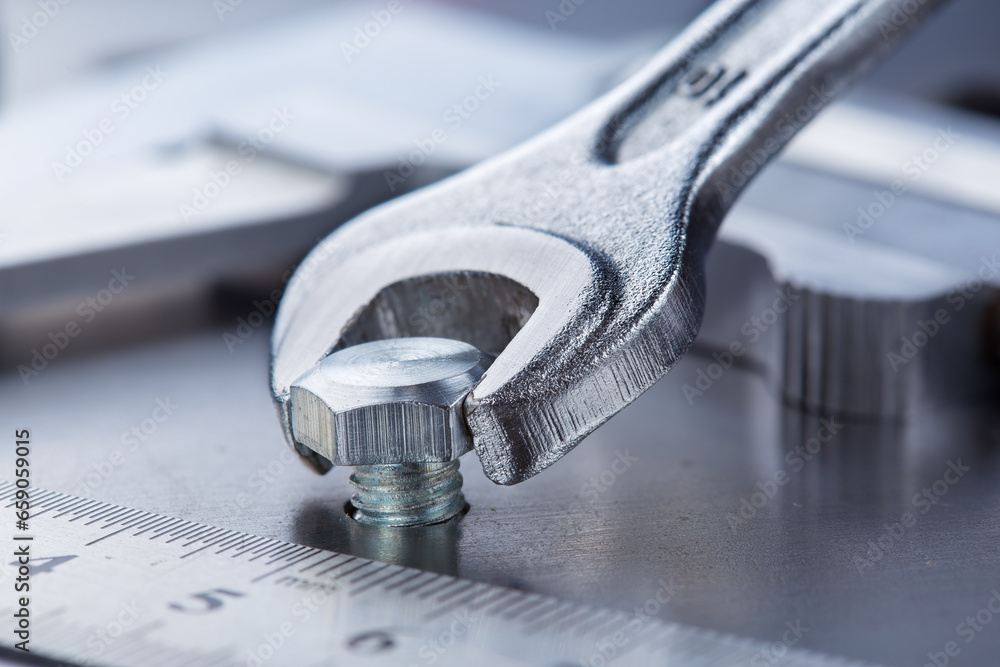 Wrench tightens bolt in steel billet. Spanner, bolt, screw and nuts. Wrench tightens bolt in steel billet. Spanner, bolt, screw and nuts.