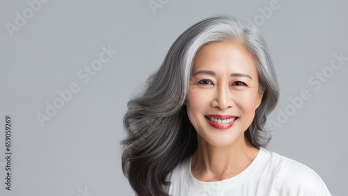 Asian beautiful woman portrait with smooth health skin face. Beautiful aging mature woman with gray hair and happy smiling touch face. Skin care beauty, skincare cosmetics, advertising concept.