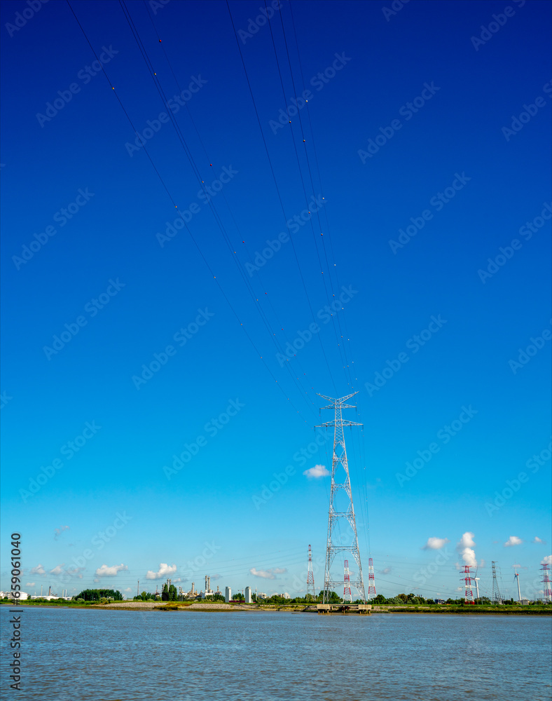 Power cables and pylons on the waterside of river Schelde in Antwerp, Belgium
