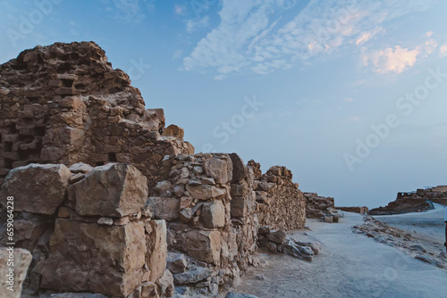 Close up of ancient fortification walls of Masada Fort built by King Herod in Israel. The stone walls remains shot against skyscape. Roman civilization. History and archeology. Landmarks of Israel.