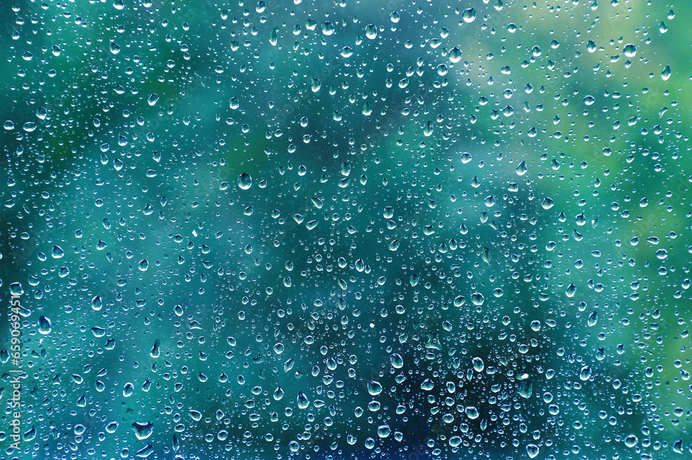 Beautiful colored drops on glass from rain on a blurred multi-colored background. Beautiful colored drops on glass from rain on a blurred multi-colored background.