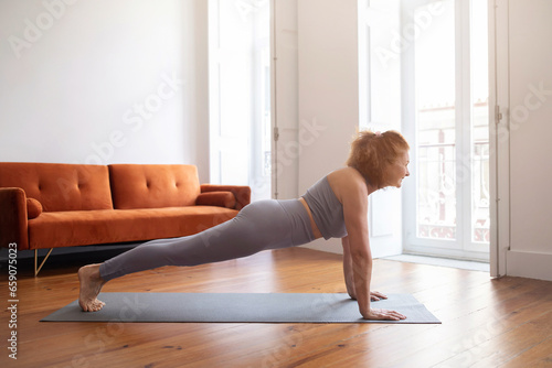 Domestic Sports. Smiling Senior Woman Doing Plank Exercise At Home