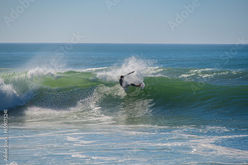 Surfer in a barrel falling under the force of the waves