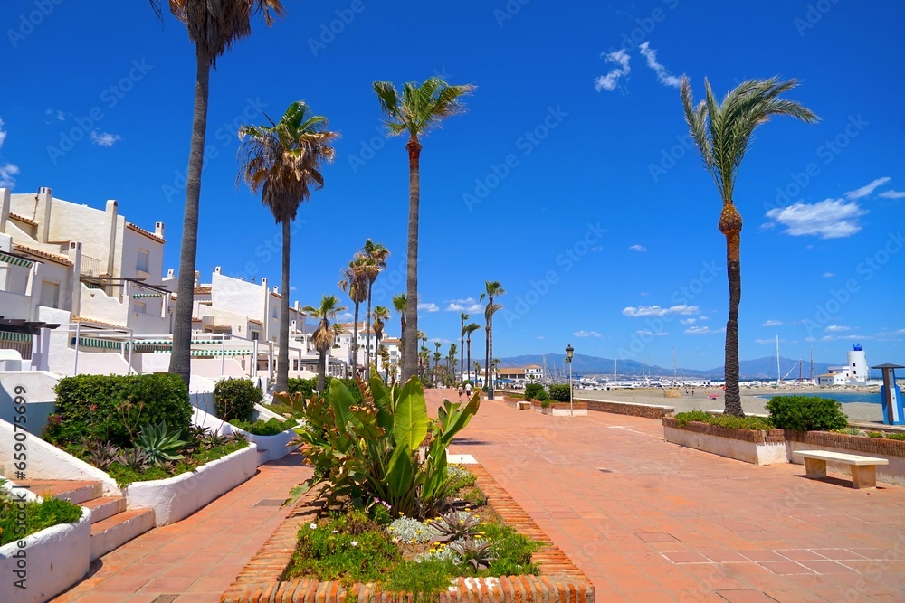 Obraz premium promenade with palm trees on the beach near the famous marina La Duquesa, Duquesa Port, Manilva, Andalusia, Estepona, Marbella, Malaga, Spain