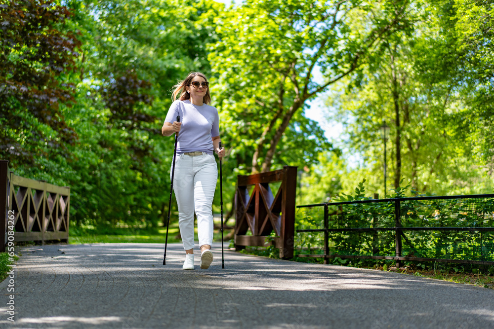 Nordic walking - woman exercising in city park Nordic walking - woman exercising in city park