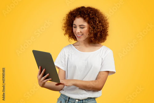 Glad teen woman using tablet for study and work