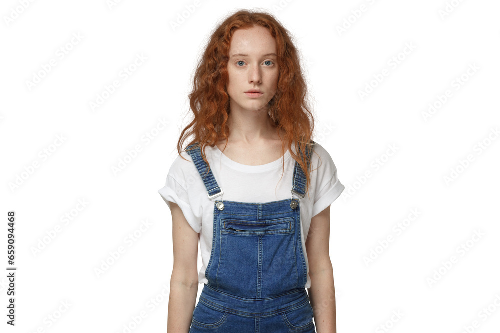 Young redhead woman standing still in denim jumpsuit, looking at camera Young redhead woman standing still in denim jumpsuit, looking at camera