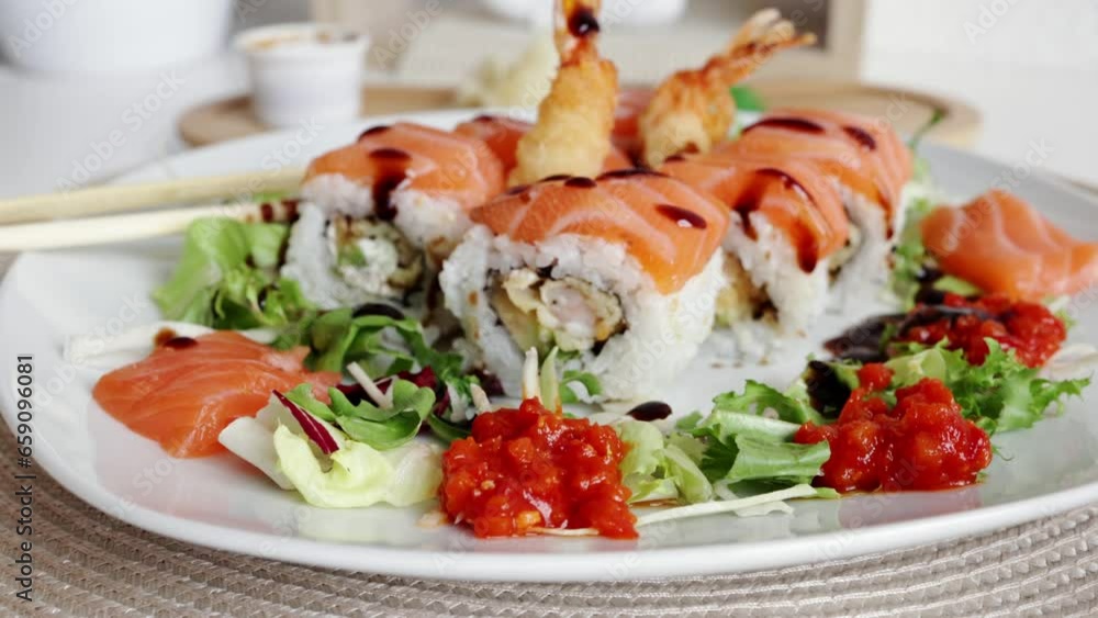 Traditional Japanese food. close-up. Sushi decorated with teriyaki sauce. Freshly cooked sushi rolls, served on a white plate at home Traditional Japanese food. close-up. Sushi decorated with teriyaki sauce. Freshly cooked sushi rolls, served on a white plate at home