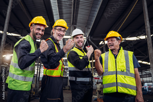 Team engineers and foreman stack hand and shake hands to show success at factory machines. Mechanical Team Operating Machinery.