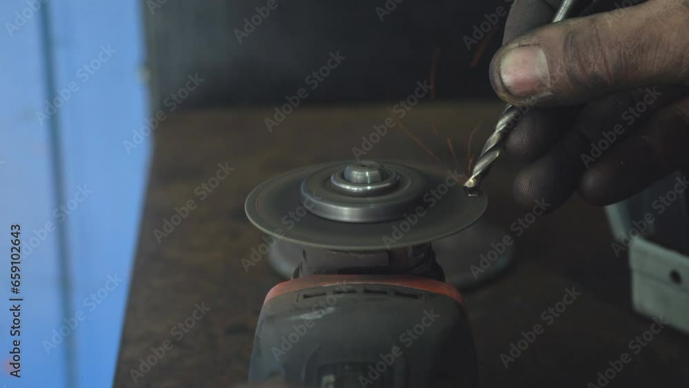 A master sharpens a drill using an emery disc. Sharpening a drill in a non-standard way using a metal-cutting tool A master sharpens a drill using an emery disc. Sharpening a drill in a non-standard way using a metal-cutting tool