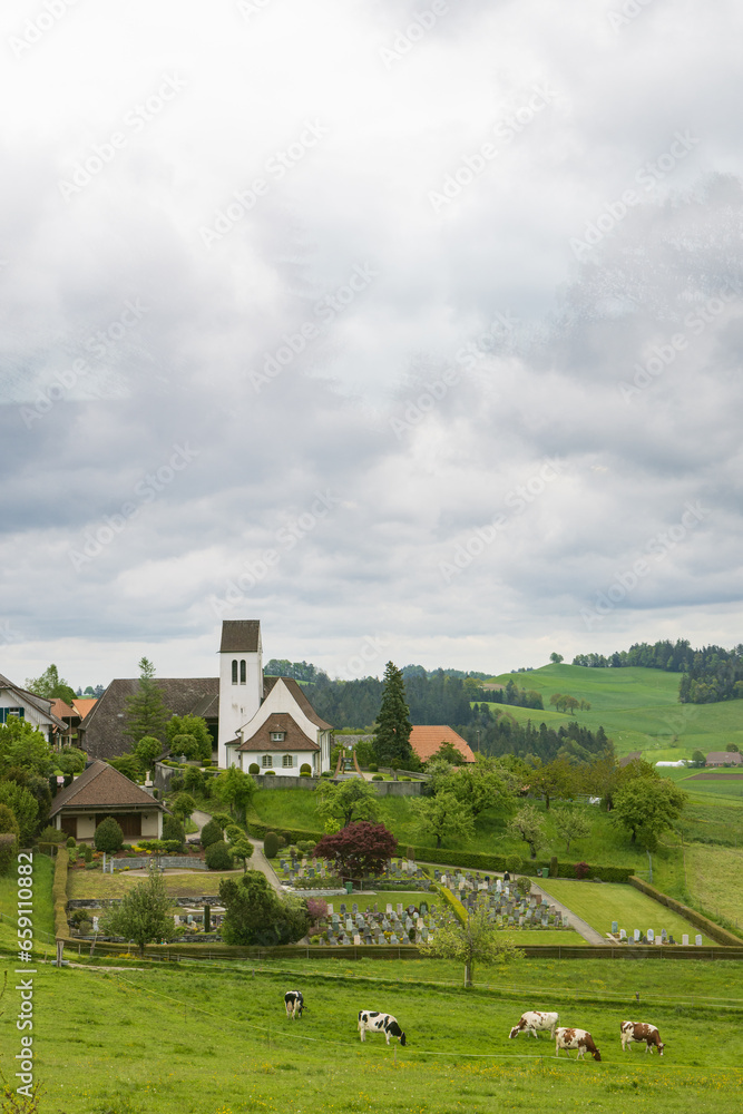 Littel white church and graveyard of Affoltern in Emmental valley canton Bern in Switzerland