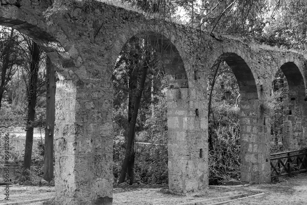Black and white aqueduct, a watercourse arch over the Rodini Park lake and walking path located in central Rhodes Black and white aqueduct, a watercourse arch over the Rodini Park lake and walking path located in central Rhodes