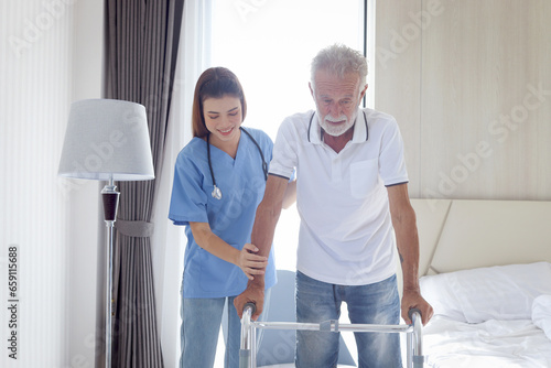 Female nurse or doctor helping elderly patient man lean to walk with orthopedic walker  patient practice walking inside house with physiotherapist  nursing senior people at house  medical health care.