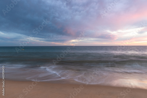 Sunset on sandy beach with ocean waves and colorful sky and clouds, Algarve, Portugal © marcin jucha