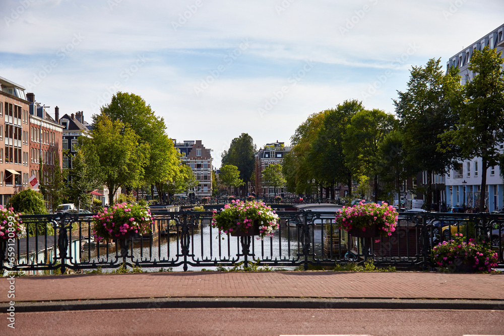 View on a canal from a bridge with flowers on the fence, selective focus