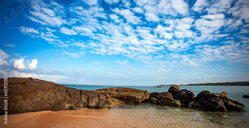 sea and rocks with white clouds in the blue sky of southern Sri Lanka beach. 