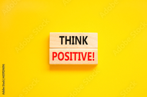 Think positive symbol. Concept words Think positive on beautiful wooden block. Beautiful yellow table yellow background. Business, motivational think positive thinking concept. Copy space.
