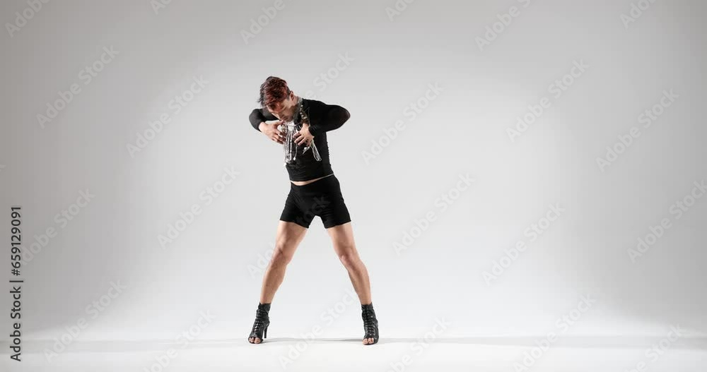 A man dressed in shorts and adorned with jewelry, delivers a captivating dance performance against a white backdrop. His charismatic and stylish moves create a visually engaging and dynamic spectacle. A man dressed in shorts and adorned with jewelry, delivers a captivating dance performance against a white backdrop. His charismatic and stylish moves create a visually engaging and dynamic spectacle.