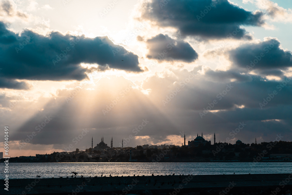 Silhouette of Istanbul with sunrays between the clouds and dramatic sky