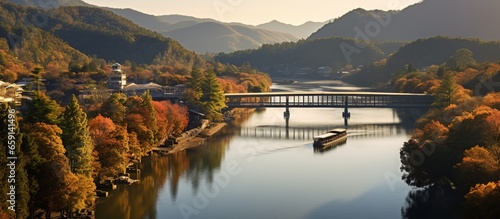 Aerial view of Arashiyama Togetsu and Togetsukyo bridge ancient architecture and boats on the river photo