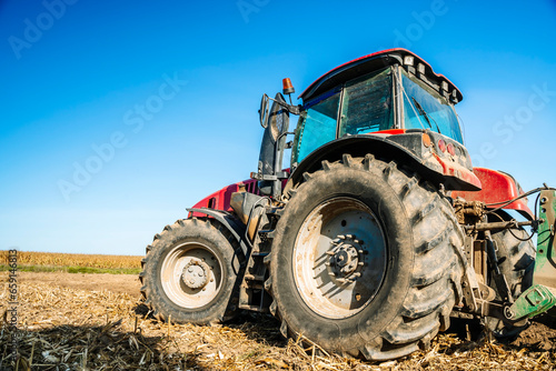 Tractor in the field. Agricultural machinery. Agricultural farm tractor during tillage of soil and field after harvest.