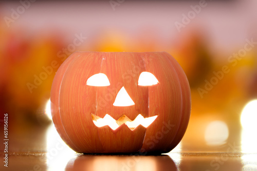 Halloween pumpkin with tealight against blurred background