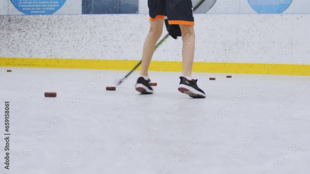 Schoolboy learning to play with stick in ice hockey arena. Starting