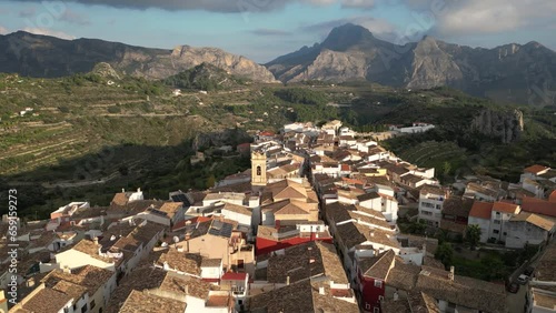 Aerial view flying 90 degrees around old town Tarbena with mountain and valley in background, Alicante, Spain