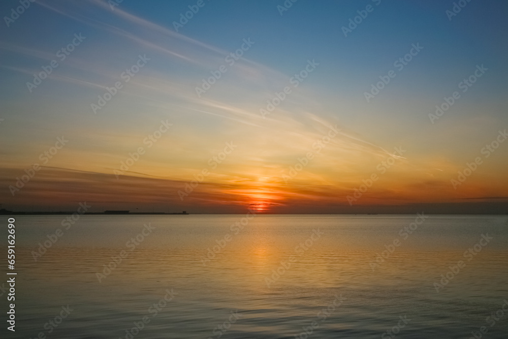 Evening seascape: Setting sun over a calm sea surface
