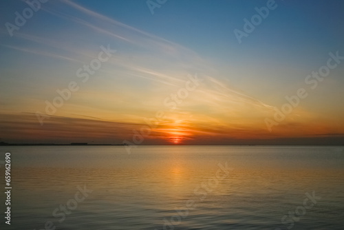 Evening seascape: Setting sun over a calm sea surface © Sergey