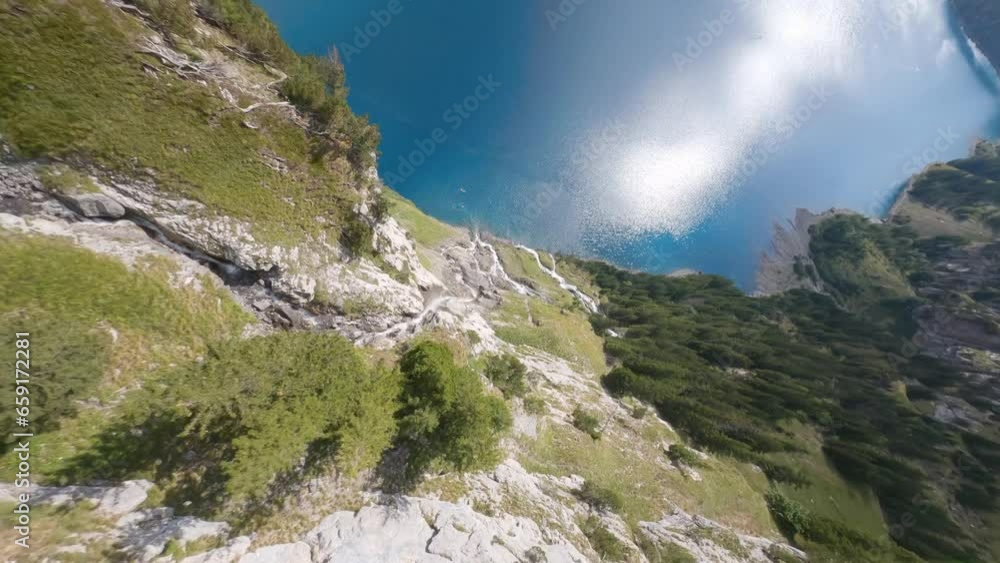 Fpv drone dive along waterfall in Switzerland mountain to a beautiful lake during sunny day Fpv drone dive along waterfall in Switzerland mountain to a beautiful lake during sunny day