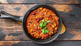 Top view of a pan of Chili Con Carne against a dark wooden background