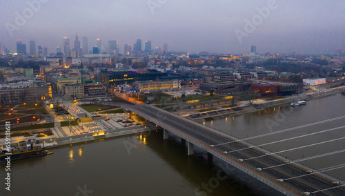 Illuminated cityscape of Warsaw with Vistula river and Swietokrzyski Bridge at dusk, Poland © JackF