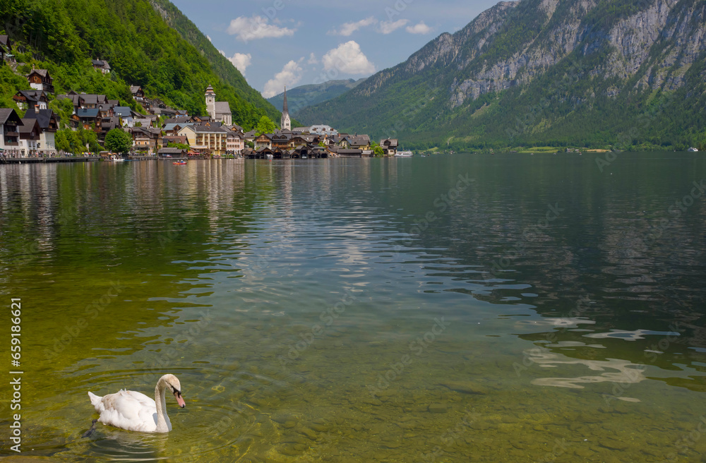 Hallstatt, a charming village on the Hallstattersee lake and a famous tourist attraction, with beautiful mountains surrounding it, in Salzkammergut region, Austria, in summer sunny day.