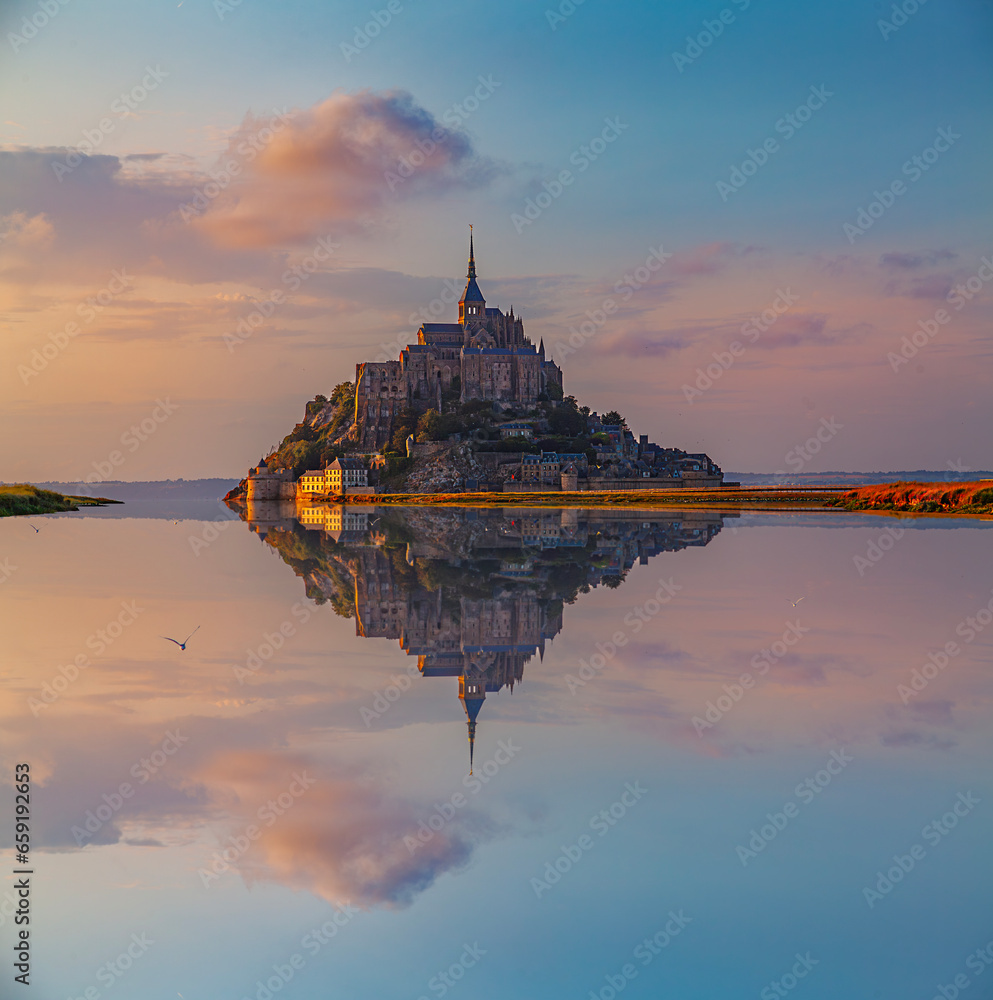 Panoramic view of the famous Le Mont Saint-Michel abbey reflected in high tide at sunset