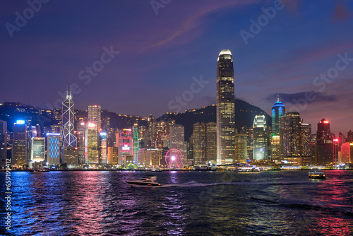 Hong Kong skyline cityscape downtown skyscrapers over Victoria Harbour in the evening illuminated with tourist boat ferries . Hong Kong, China © Dmitry Rukhlenko