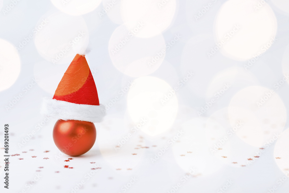 Fototapeta premium Christmas ball with Christmas hat on white background