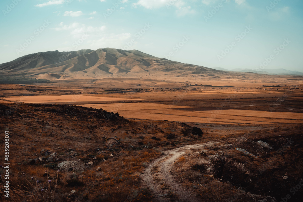 The brown autumn hills, fields, farms, and the countryside road in Armenia countryside.