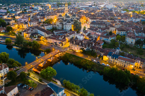 View from drone of illuminated houses and ancient Catholic Cathedral of Perigueux town at summer night, France