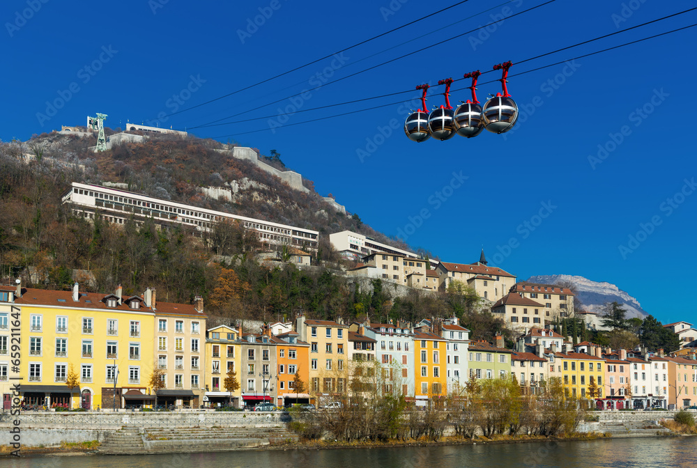 Fototapeta premium Image of cable cars in Grenoble in autumn over riverside, France.